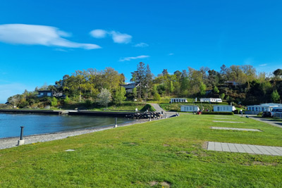 Stolpestad Camping ved sjøen med gressbakke og brygge